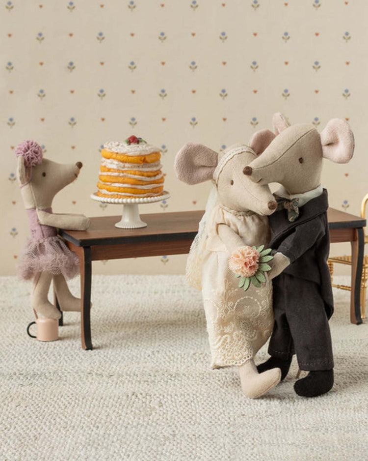 The maileg wedding mice couple in box, mum and dad, feature charming fabric bride and groom mice dancing at their wedding, with another mouse near a layered cake—making this a delightful wedding gift.
