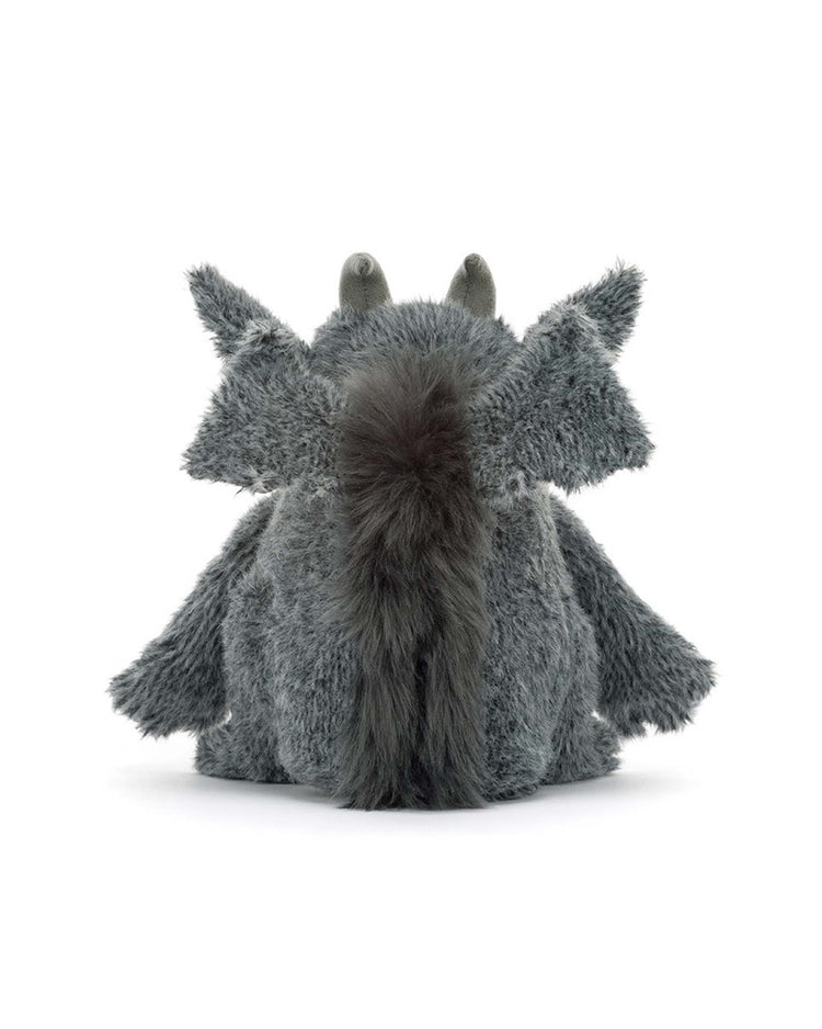 The Jellycat Growlston Gargoyle is a plush toy made from soft polyester plush, featuring gray fur, large pointed ears, a bushy tail, and two small horns; it is shown from the back against a white background.
