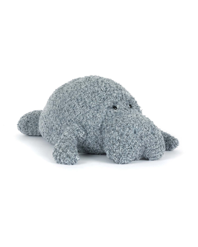 A plush, gray maffles manatee by jellycat with a round body and large snout lies on a white background—perfect for an ocean breeze–themed nursery or as a cute companion in any cozy space.