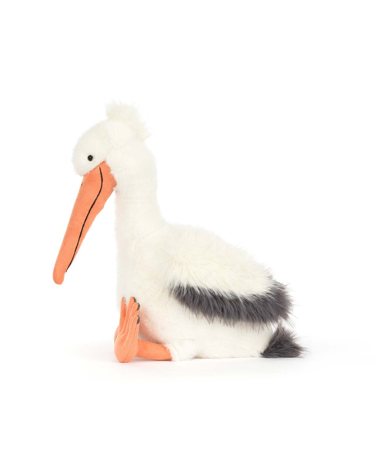 Keli Pelican by Jellycat is a plush toy with a long orange beak, white fluffy body, black wing patches, and orange feet—perfect for fans of The Beak.