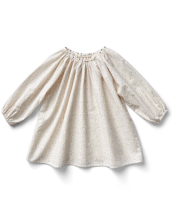 The "peasant tunic in confetti print, blueberry" by Soor Ploom is a cream-colored, long-sleeve blouse from Portugal. It has a round neckline and a charming small floral pattern with a subtle confetti print.