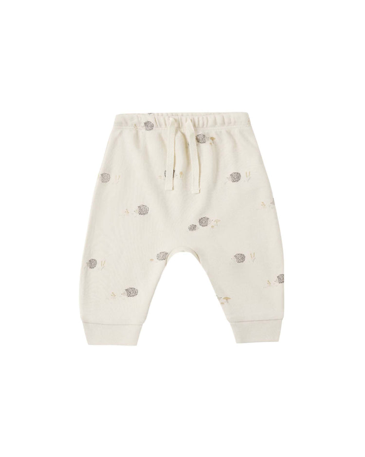 The quincy mae drawstring pant in hedgehog is crafted from off-white organic cotton for babies, featuring a comfortable elastic waistband with a drawstring, subtle hedgehog print with small rabbits, cuffed ankles, and a relaxed fit for all-day comfort.