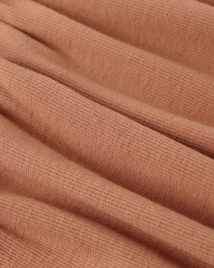 Close-up of the soft, ribbed fabric of the quincy mae ribbed tank dress in poppy, showing its light texture and gentle diagonal folds.