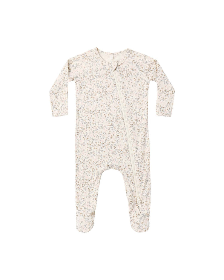 The quincy mae bamboo zip footie in bloom is a long-sleeve, footed baby onesie with a light beige background and a delicate floral print. Featuring an angled zipper from neck to leg and fold-over hand mitts, this bamboo footie offers added comfort and warmth.