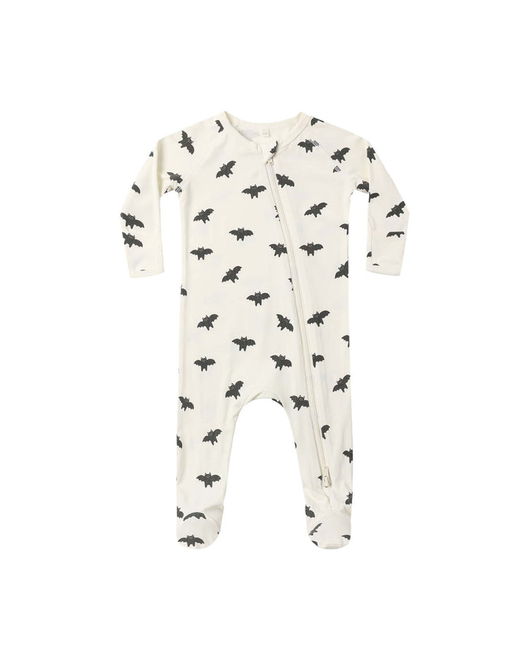 The quincy mae bamboo zip footie in bats is a white baby sleeper with long sleeves and footies, featuring a repeating black bat pattern and a convenient diagonal double-zip closure from neck to left leg.