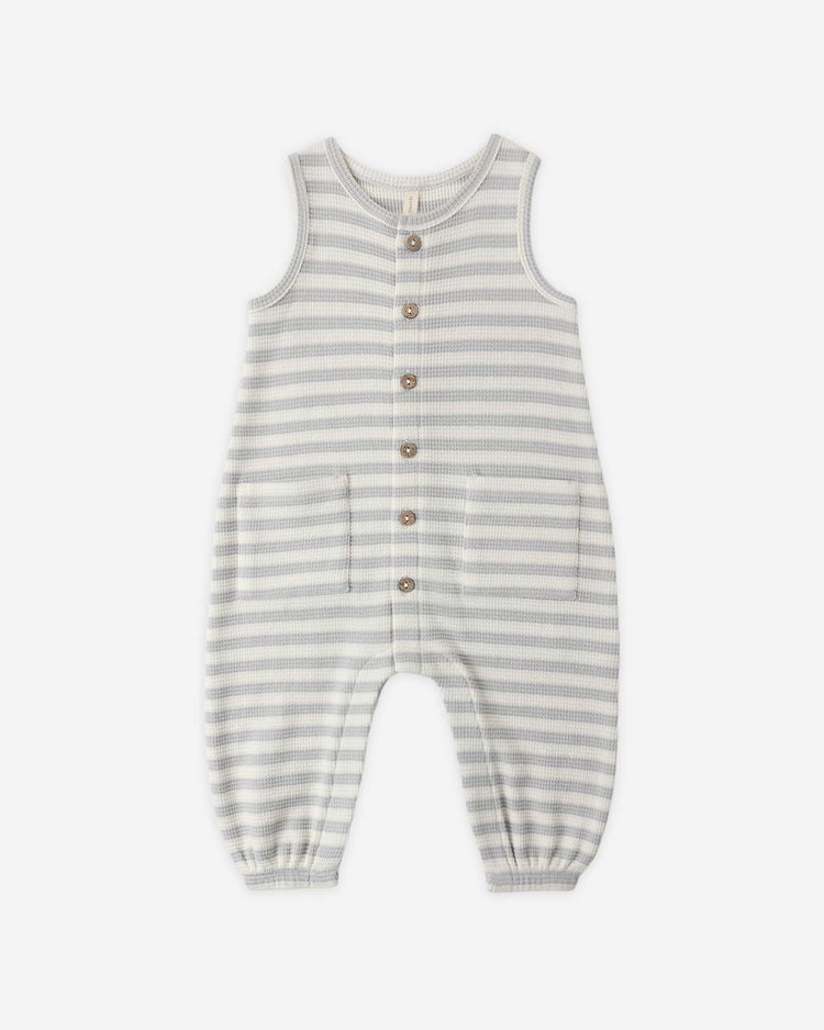 The quincy mae waffle jumpsuit in sky stripe features gray and white stripes, sleeveless design, front buttons, two pockets, and elastic leg openings—perfect for baby's transitional wardrobe. Shown laid flat on a white background.