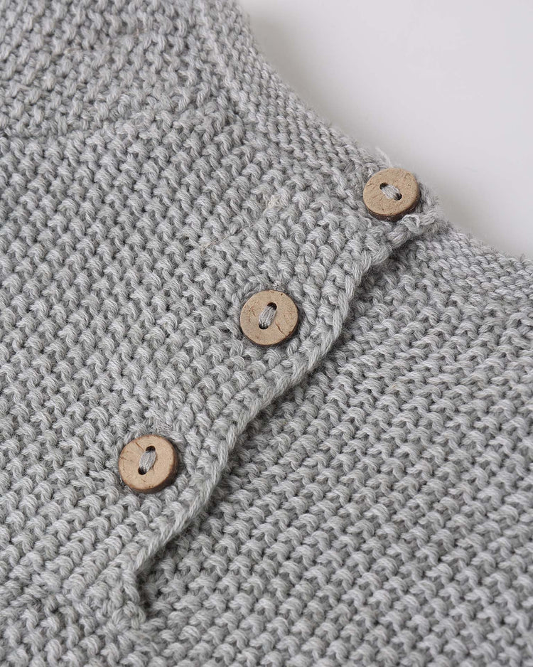 Close-up of the "summer knit set in heathered sky" by quincy mae, featuring a light gray knitted organic cotton sweater with three wooden buttons for a simple, cozy texture.