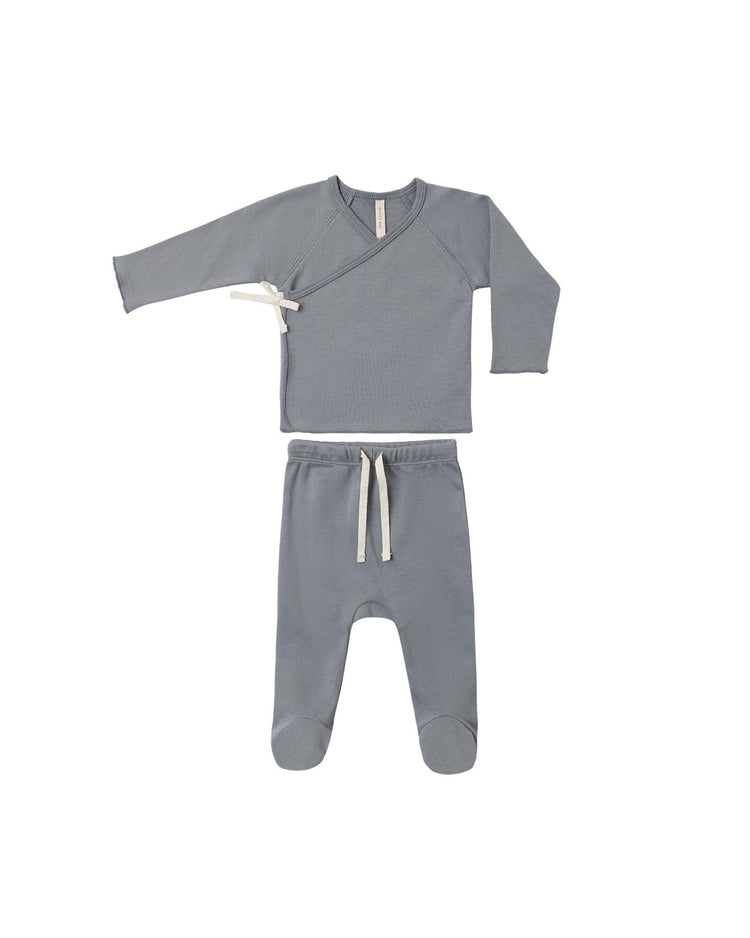 The quincy mae wrap top + footed pant set in slate features a soft organic cotton long-sleeve wrap top with a side tie, paired with matching footed pants with a white drawstring—an ideal coming home outfit for newborns. Both pieces are displayed laid flat on a white background.