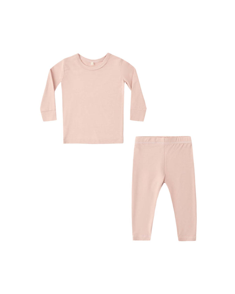 A bamboo pajama set in dusty rose by quincy mae, designed for children with a slim-fit long sleeve top and pants, is laid flat on a white background.