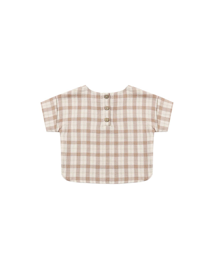 The *quincy mae* woven boxy top in rustic plaid is a short-sleeve, beige and light brown shirt made from organic cotton, featuring a relaxed boxy fit and three buttons on the back, displayed flat against a white background.