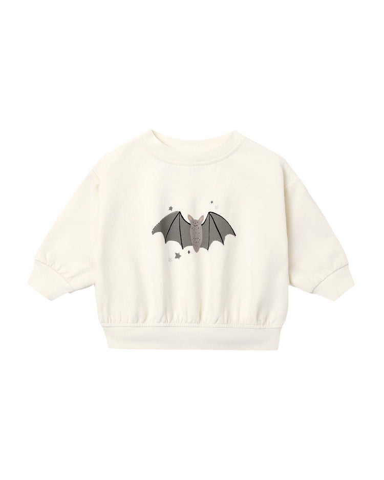 The quincy mae relaxed fleece sweatshirt in baby bats is crafted from cream-colored organic cotton for children. It features a playful baby bat print with small stars on the front, long sleeves, and elastic cuffs and hem for extra comfort.