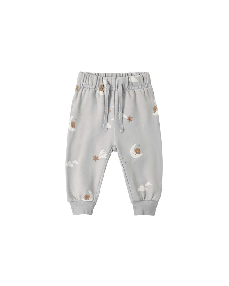 The quincy mae relaxed sweatpant in sky friends is crafted from organic cotton in light grey, featuring a charming print of brown moons, clouds, and stars. These baby jogger pants are designed with a relaxed sweatpants fit, elastic waistband, and drawstring. Pants are displayed on a white background.