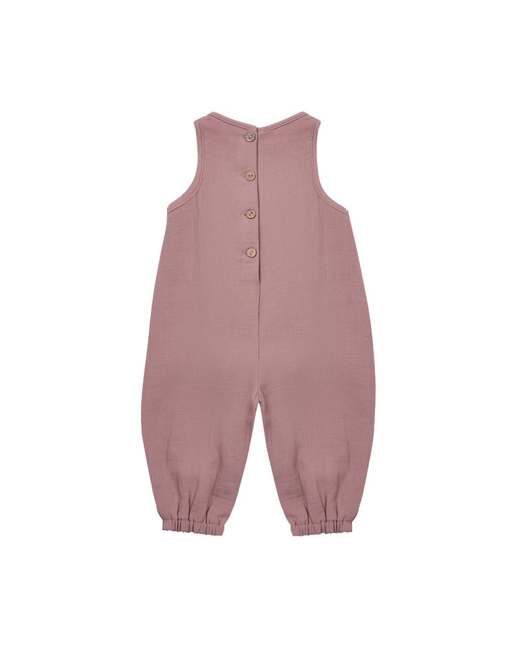 The maisie overall in mulberry by quincy mae is a sleeveless children's jumpsuit, crafted from organic cotton for a soft feel, featuring wooden buttons down the back and elastic cuffs at the ankles. This lightweight baby romper is shown on a plain white background.
