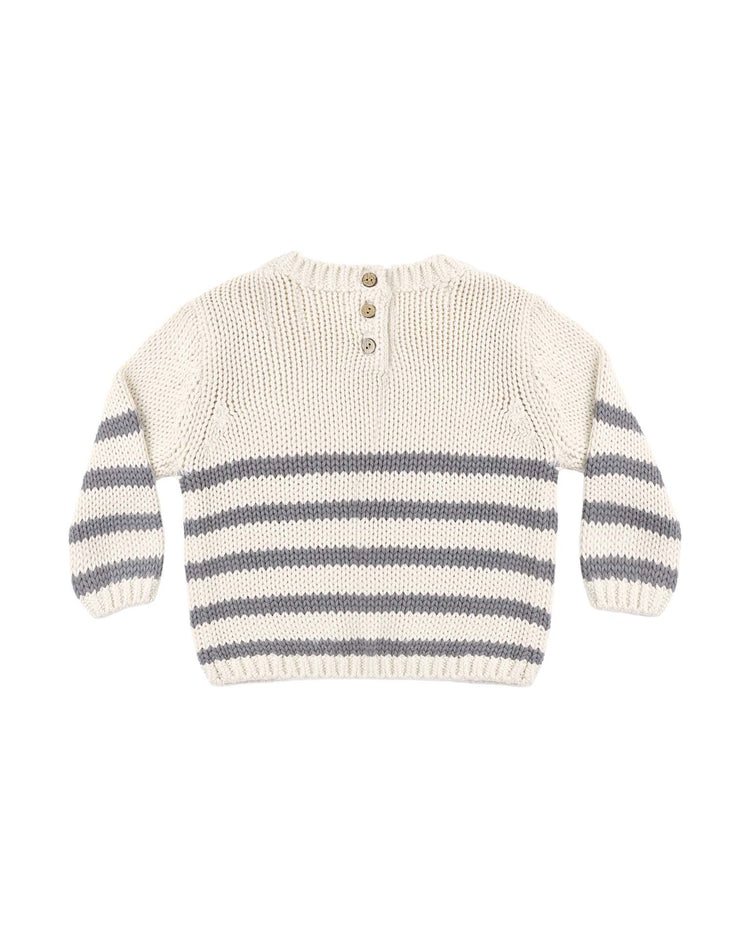 The rex sweater in slate stripe by quincy mae is a cream-colored organic cotton sweater with gray horizontal stripes on the body and sleeves, featuring three brown buttons at the back of the neck.