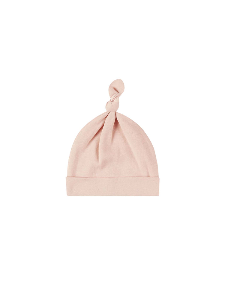 The quincy mae knotted baby hat in dusty rose is crafted from soft organic cotton and features a folded brim with a single top knot, shown here on a white background.