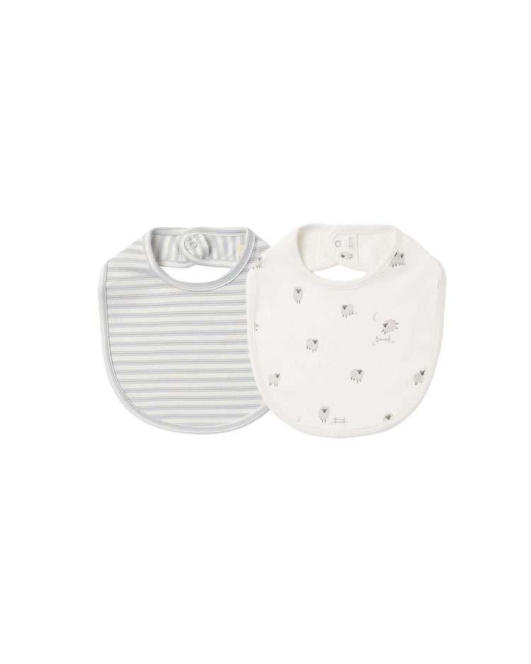 Introducing the quincy mae jersey snap bibs in sheep + cloud stripe: this set includes two soft, organic cotton bibs—one featuring gray and white stripes, and the other adorned with delicate gray sheep and balloon illustrations on a white background. Designed for your little one’s comfort, both bibs offer a rounded shape and secure snap closures at the neck.