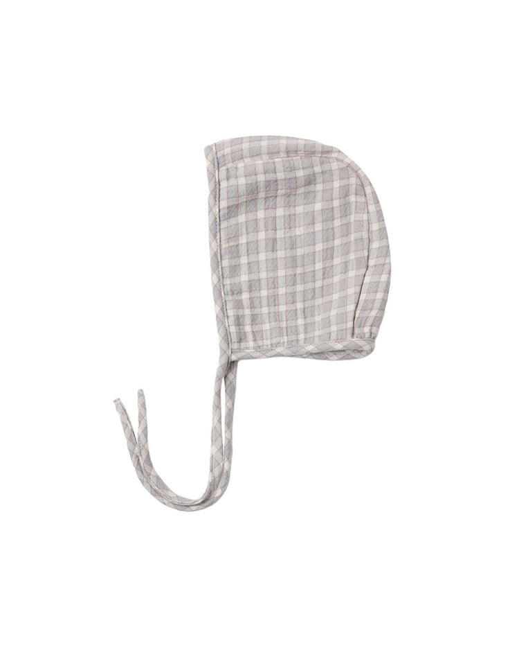 A lightweight, plaid-patterned organic cotton baby bonnet with two strings for tying, displayed on a white background.