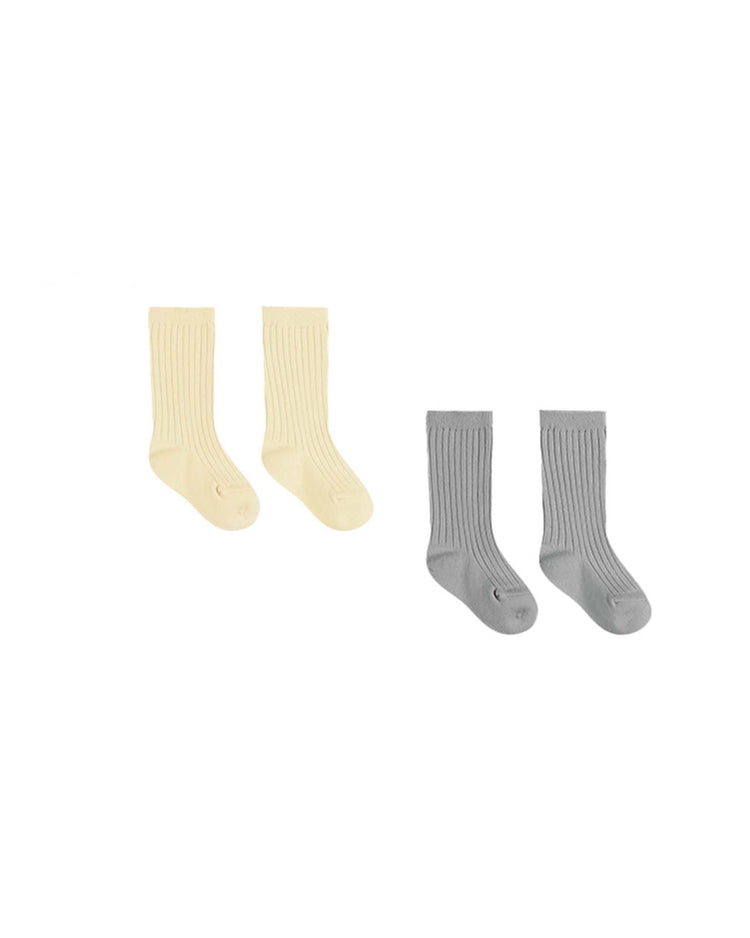 The charming Quincy Mae sock set includes two pairs of ribbed cotton socks: one in cheerful yellow and the other in soft gray, beautifully packaged on a pristine white background.