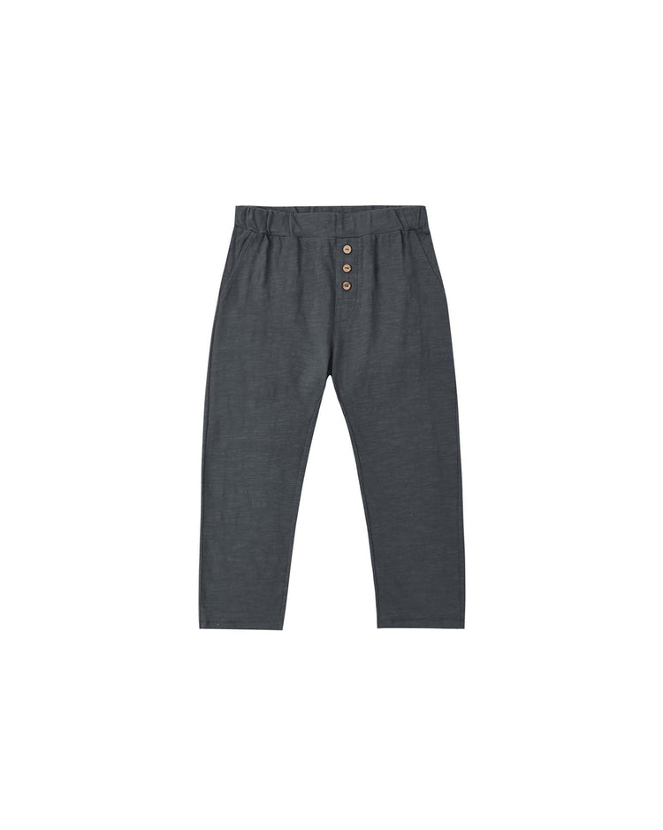 PREORDER rylee + cru cru pant in midnight, crafted from soft cotton in a deep gray hue, features an elastic waistband and three brown buttons on the front. These pants offer a relaxed fit with straight legs and are displayed flat on a white background.
