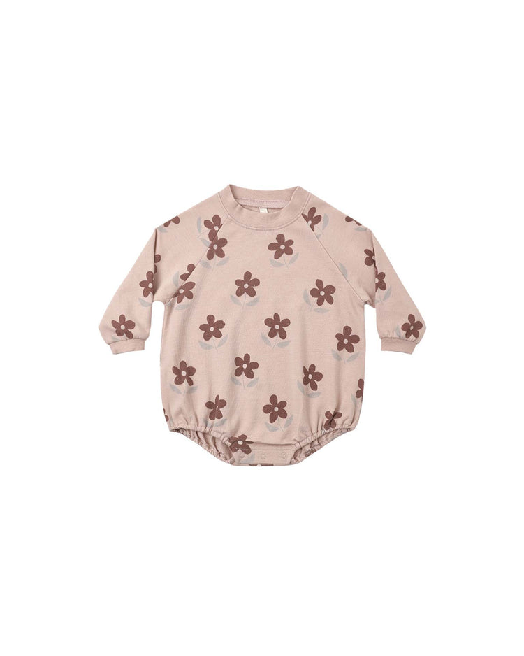 The rylee + cru PREORDER crew neck romper in daisy is a baby long-sleeve romper in light pink, featuring an all-over brown daisy print, elastic leg openings, and convenient snaps at the bottom.