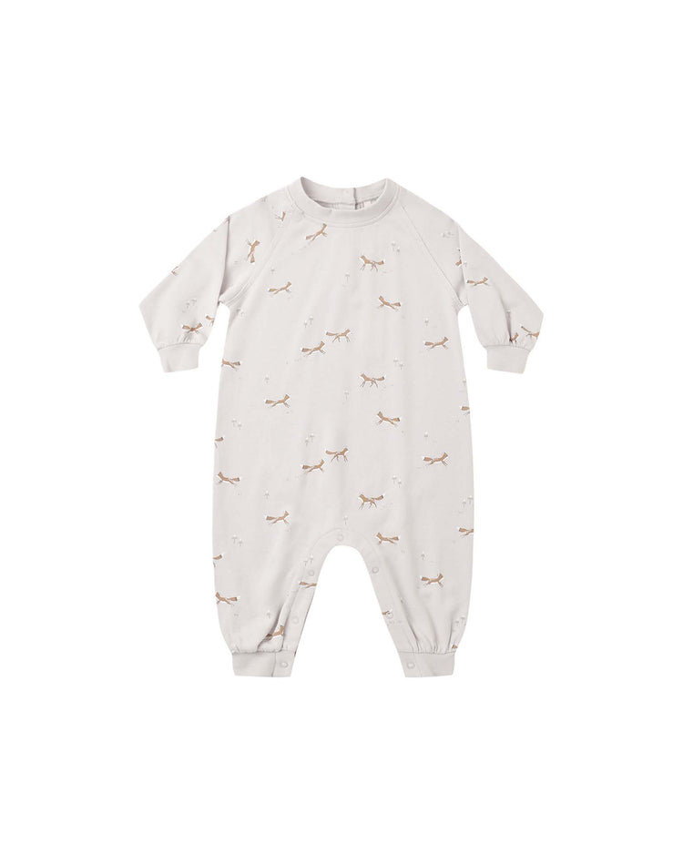 A raglan jumpsuit in the foxes print by rylee + cru, made from soft French terry in a cream color, with long sleeves, snap closures at the legs, and cuffs at the wrists and ankles, is laid flat on a white background.