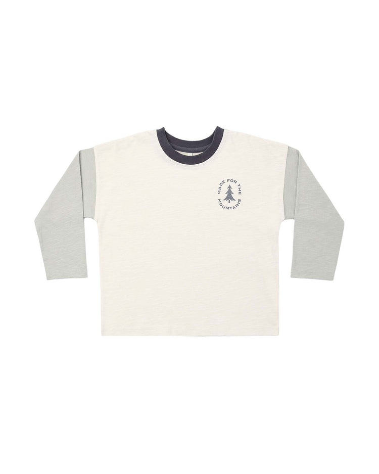 The PREORDER camden long sleeve tee in made for the mountains by rylee + cru is a 100% cotton raglan t-shirt with a cream body, light gray sleeves, and a dark gray collar. Featuring a small tree graphic and text on the left chest, this classic baby tee offers an effortlessly cool vibe.
