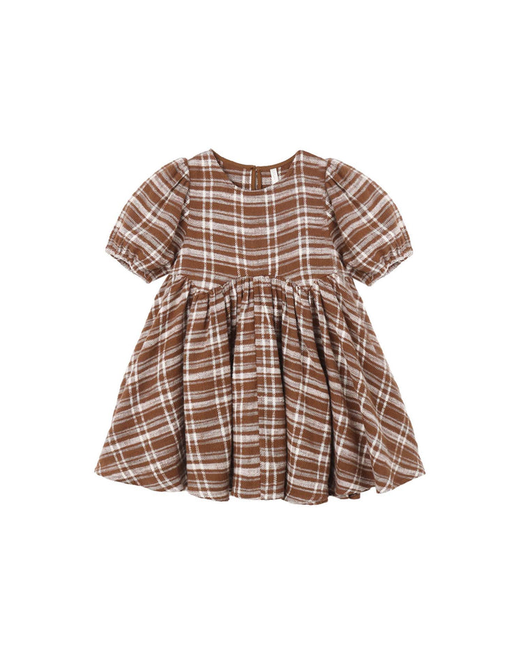 The rylee + cru Rose Dress in Aspen Plaid features a charming brown and white plaid pattern, short sleeves with slight puff detailing, a round neckline, and a gathered skirt. This delightful mini dress is shown on a white background, blending timeless style with playful accents.