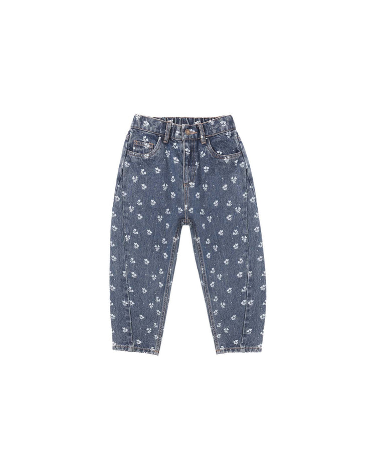 The “barrel pant in heart ditsy” by rylee + cru features indigo denim with a relaxed fit and an allover heart ditsy print. Designed with front and back pockets, belt loops, and a button closure, these pants are shown against a white background.