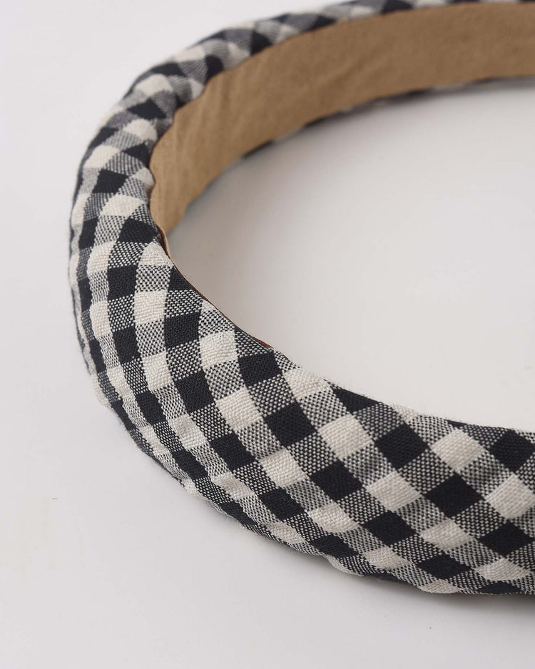 A close-up of the rylee + cru padded headband in black check, featuring a black and white checkered fabric, photographed on a white background.