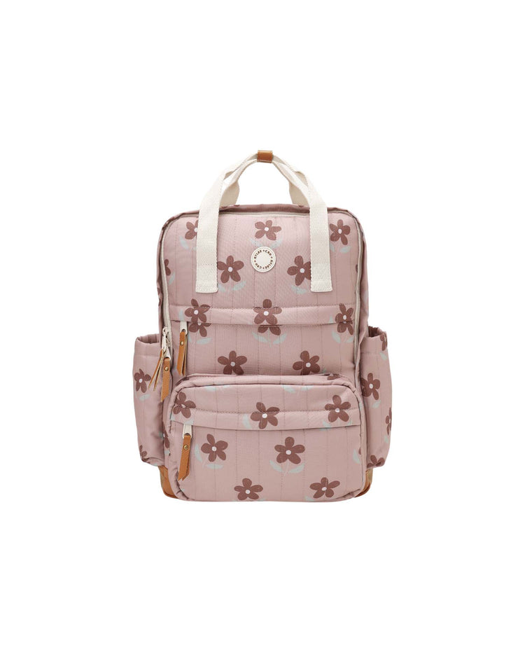 The "backpack in little daisy" by rylee + cru is a stylish pink polyester backpack featuring white handles, brown daisy patterns, front zipper pockets, and two side pockets—perfect for everyday adventures. Shown on a white background.