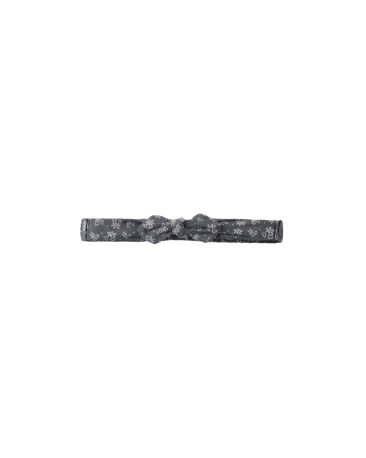 A soft linen viscose baby bow headband in heart ditsy by rylee + cru, featuring a subtle white floral heart print on gray and displayed against a plain white background.