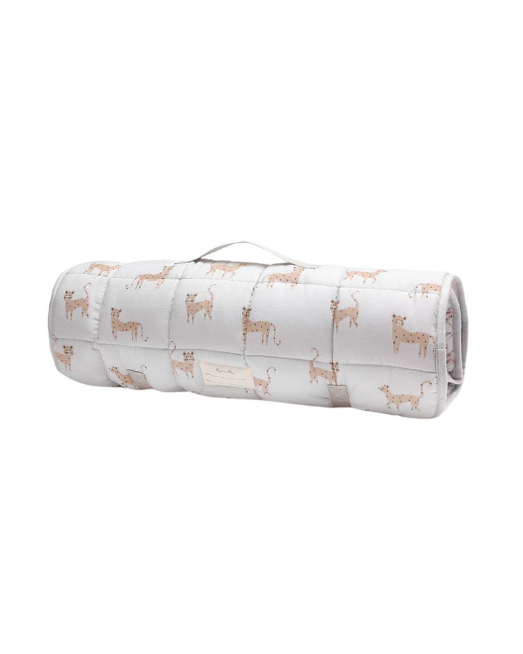 Rolled-up white quilted nap mat in leopard by rylee + cru, with a handle, featuring a repeating pattern of illustrated leopards and including a cozy removable pillow.