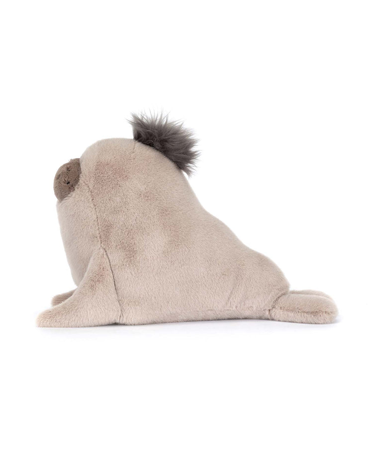 The roarwell sea lion by Jellycat is a plush toy with light brown fabric, a round dark nose, and a fluffy dark tuft on its head, shown in side profile against a white background.