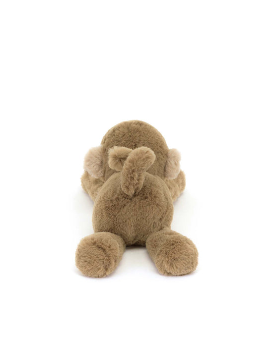 The Jellycat smudge monkey tiny, plush and fluffy, lies on its stomach with legs spread wide, set against a pristine white background.