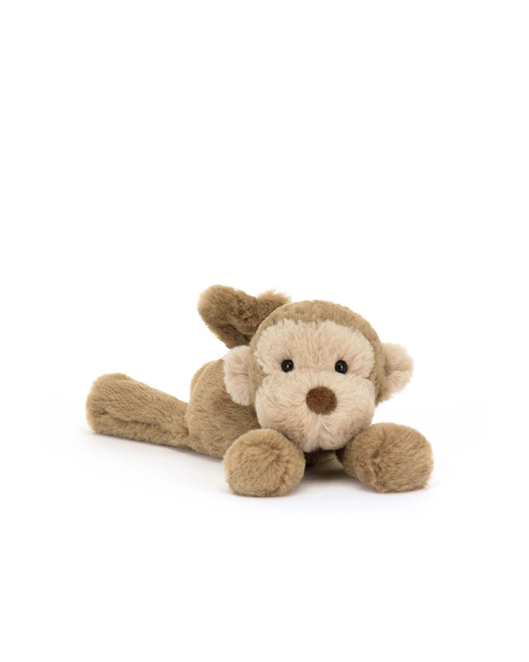 A plush toy by Jellycat, named the "Smudge Monkey Tiny," features a fluffy brown monkey with a white face and dark eyes, resting on a clean white background.