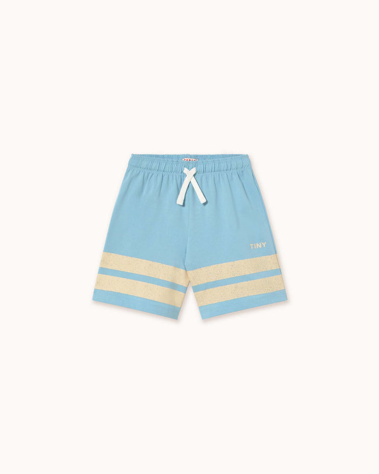 Dusty blue children's shorts from Tiny Cottons, made of organic cotton with two beige stripes on each leg and a white drawstring waistband. "TINY" is printed on the left side, highlighting Tiny Cottons' unique prints.