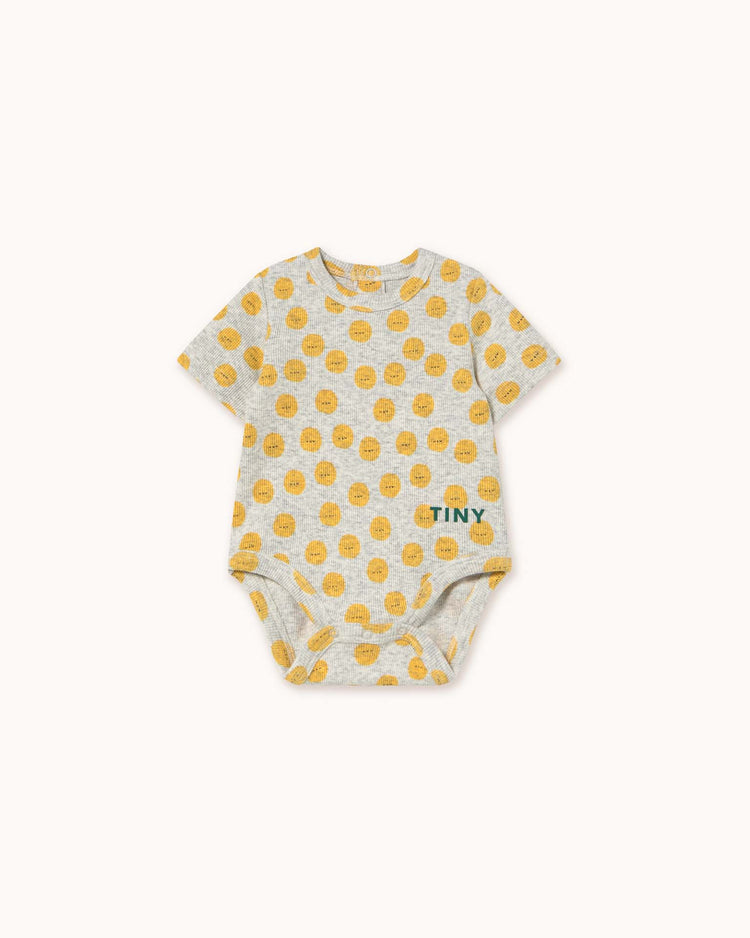 Light grey heather sun body with short sleeves, featuring a yellow circular pattern and the word "TINY" in green on the right side. Crafted by tiny cottons, it offers unique prints and high-quality clothing for your little one.