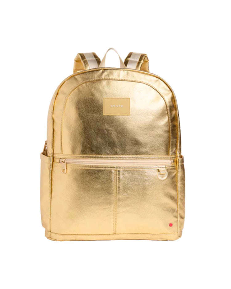 The Kane Large Double Pocket Backpack in Gold by STATE Bags features a shiny gold finish, front and side pockets, a top handle, and adjustable straps. This stylish backpack includes a rectangular STATE label with a small red dot near the bottom right corner.