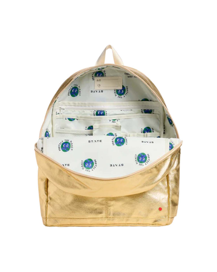 Kane Large Double Pocket Backpack in Gold by STATE Bags with the main zipper open, revealing a white interior lining printed with blue and green circular logos and multiple organizational pockets—perfect as a stylish school backpack.
