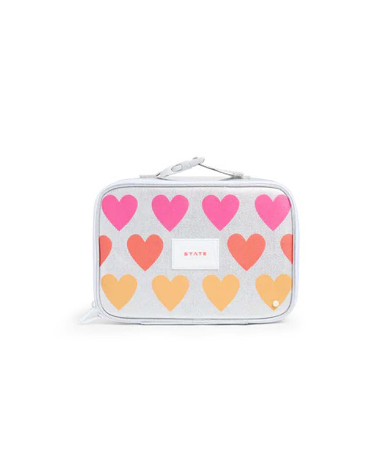 Introducing the Rodgers Lunch Box in Happy Fuzzy Hearts by State Bags—a rectangular, silver kids lunch box adorned with a playful pattern of pink and orange hearts. Featuring a white zipper, a convenient small handle on top, and STATE displayed prominently on a white center label, this insulated lunch box showcases State Bags’ signature design. Both stylish and functional, it’s ideal for everyday use.