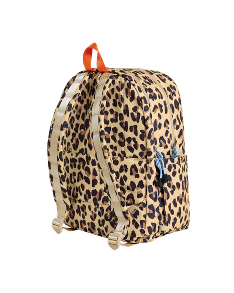 The State Bags Kane Double Pocket Backpack in Leopard features a chic leopard print with beige and black spots, beige straps, an orange top handle, and a double front pocket. This stylish kids’ school backpack by State Bags is displayed upright against a white background.