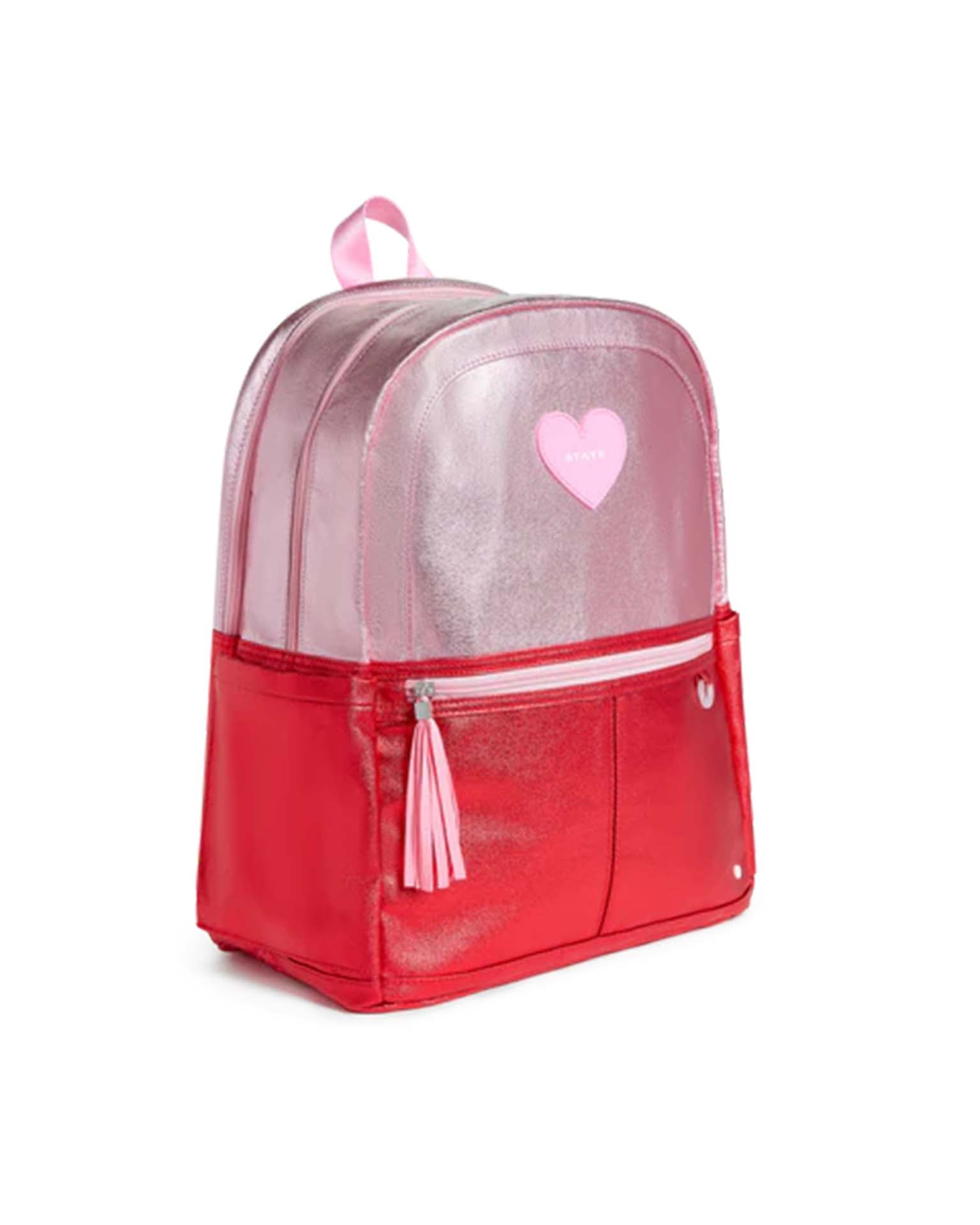 Sure! Here’s your rewritten sentence using the provided product data: The Kane Double Pocket Backpack in pink + red colorblock by STATE Bags features a shiny, metallic finish, a pink heart patch, front zipper pocket with tassel, and a pink top handle—shown on a white background, it’s the perfect addition to any school backpack collection.