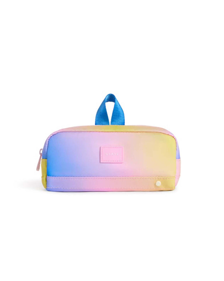 The Clinton Pencil Case in a blue, pink, and yellow gradient from STATE Bags is a small rectangular pouch featuring a blue fabric top handle, zipper closure, and a small front label. Designed for everyday use, this durable pencil case combines style and practicality.