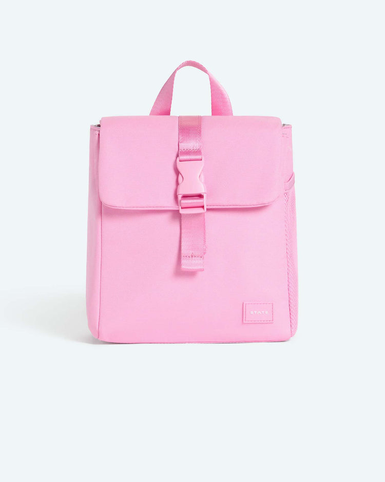 The richmond lunch sack in pink by state bags is a small, light pink bag featuring a top handle, a front flap secured by a buckle, and a small rectangular patch label on the lower front—ideal for pairing with an insulated lunch sack or kids lunch box—shown against a plain white background.