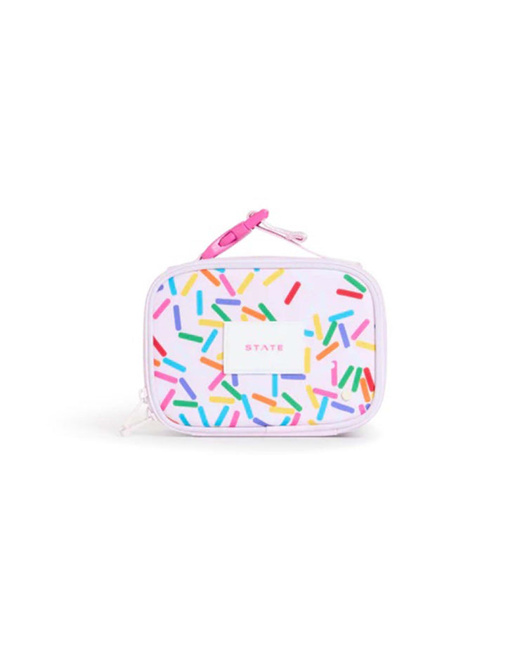A rectangular white lunchbox with colorful sprinkle-like patterns and a pink zipper, the mini rodgers snack pack in sprinkles by state bags features the brand’s name printed in the center. This insulated lunchbox keeps food fresh while bringing a playful touch to lunchtime.