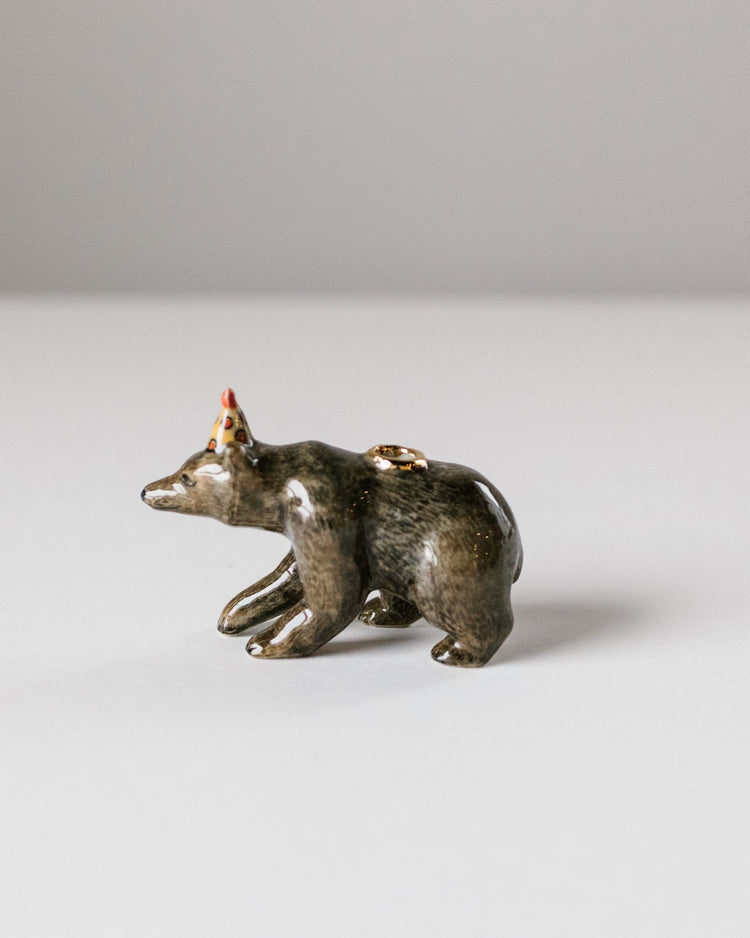 Ceramic figurine of a brown bear cake topper painted in glossy brown with a crown on its head, positioned on a plain white background. (camp hollow)