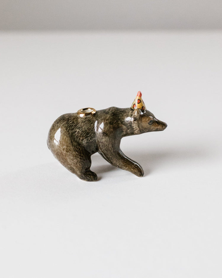 A small figurine of a brown bear cake topper on all fours, crafted in a glossy, metallic finish with a colorful headdress and heirloom-quality craftsmanship by Camp Hollow.
