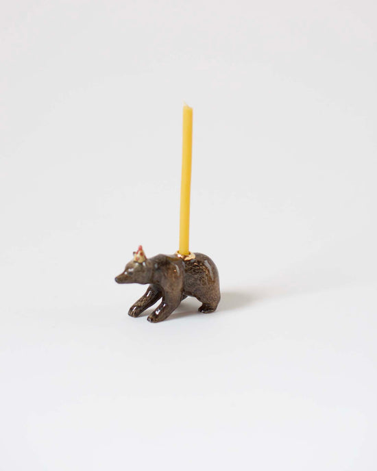 A bronze, heirloom-quality craftsmanship candle holder shaped like a bison with a single yellow candle inserted on its back, set against a white background.