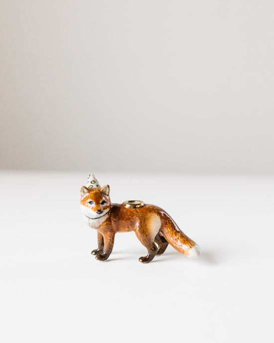 A small, ceramic figurine of a Camp Hollow Red Fox Cake Topper with a detailed, glossy finish standing on a plain white background.
