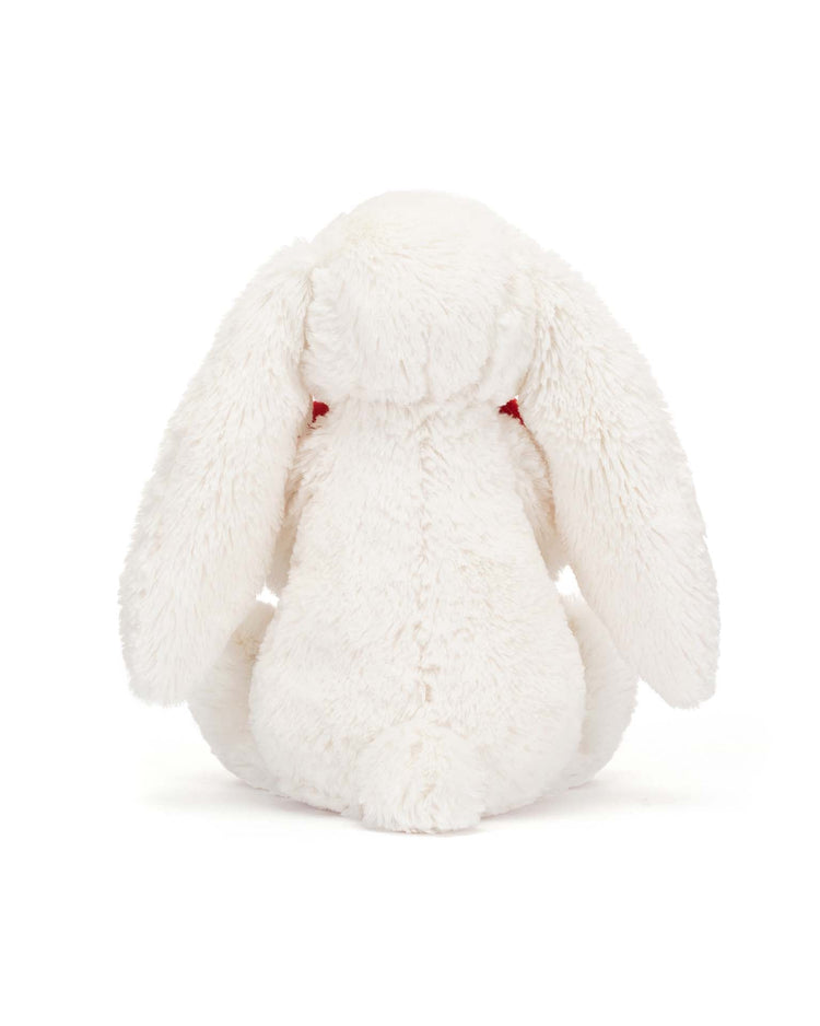 Back view of a super soft, white plush stuffed bunny from Jellycat's Bashful Red Love Heart Bunny Little collection, featuring long floppy ears and a bashful red love heart on its chest.